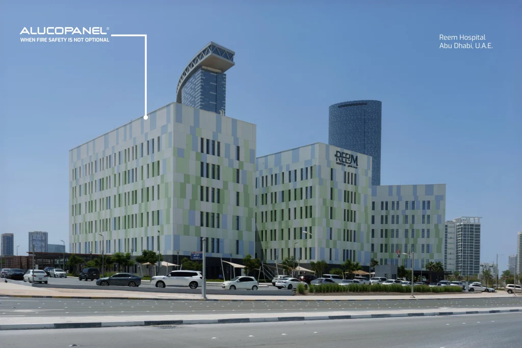 Reem Hospital in Abu Dhabi with 23,000 sqm of custom-colored Alucopanel® A2 fire-safe cladding in light green, white, soft blue, and grey.