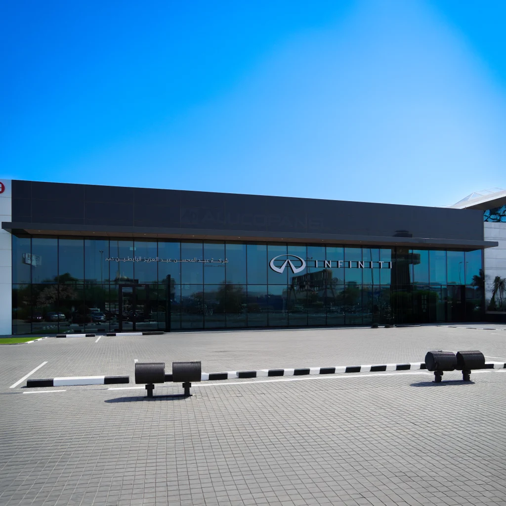 Angled view of INFINITI Showroom exterior in Al Rai, Kuwait, demonstrating the reflective depth and contemporary design achieved with Alucosign® FR panels.